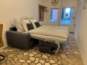 Cama en habitación con sofá y ventana en Charmantes Brauerei-Altstadtgewölbe, en Laufen