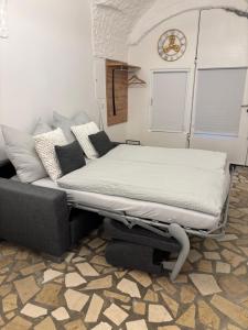 Una cama en una habitación con un sofá y un reloj. en Charmantes Brauerei-Altstadtgewölbe, en Laufen