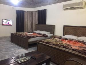 a hotel room with two beds and a table at Star Hotel Lahore in Lahore +9 photos