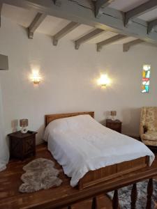 a bedroom with a bed and two tables and a chair at La Tour in Béziers