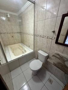 a bathroom with a toilet and a bath tub at Hotel Brasília Park in Novo Gama