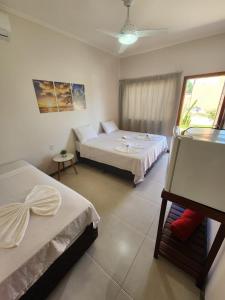 a hotel room with two beds and a window at Pousada Canto do Sabiá in Piúma +115 photos