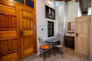 a kitchen with a table and chairs next to a door at Riad Alouch in Fès