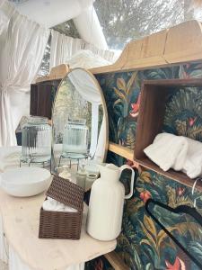 a bathroom with a table with a mirror and a sink at Le Dôme du Lac in Prouilly