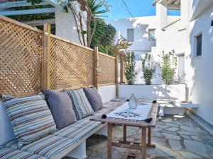 een houten bank op een patio met een tafel bij Paros Iconic Apartments in Kampos Paros