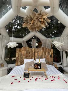 a bedroom with a bed with a table with roses on it at Le Dôme du Lac in Prouilly
