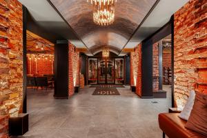 un pasillo con una pared de ladrillo y una lámpara de araña en Hotel Kakola, en Turku