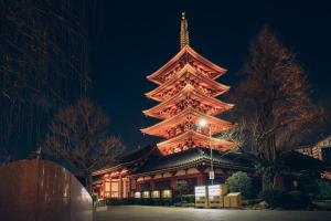 a large building with a large tower at night at M house asakusa kaminarimon tokyo in Tokyo