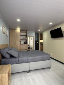 a bedroom with a bed and a flat screen tv at Hostelfc Loft 60 in Bogotá
