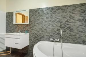 a bathroom with a bath tub and a sink at Cristina Grand in São Vicente +27 photos