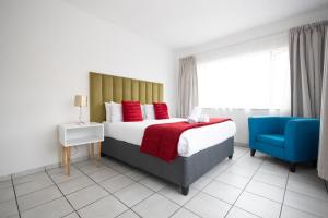 a bedroom with a bed and a blue chair at Safi Luxury Apartment 2 in East London