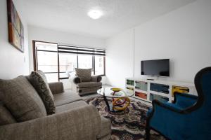 a living room with a couch and a tv at Safi Luxury Apartment 2 in East London