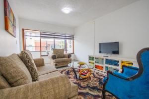 a living room with a couch and a tv at Safi Luxury Apartment 2 in East London