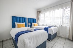 two beds in a room with a window at Safi Luxury Apartment 2 in East London +3 photos