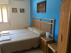 una camera da letto con due letti e una parete blu di Hotel Il Triangolo ad Agnone Bagni