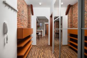 Pokój z ceglanymi ścianami i korytarzem z drewnianymi podłogami w obiekcie Old Town Apartment Spilberk by Goodnite cz w mieście Brno