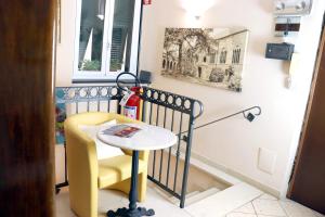 a small table and a yellow chair in a room at ALBERGO LOCANDA DIANA in Genoa