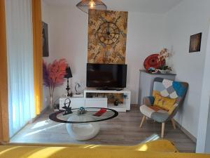 a living room with a tv and a table at Chic et douillet in Perpignan
