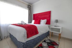 Un dormitorio con una cama grande con cabecero rojo. en Safi Elegant Self-catering Suite 5, en East London