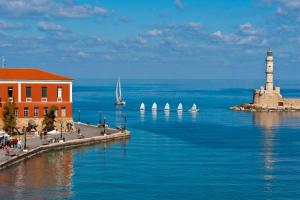 a lighthouse in the ocean with sailboats in the water at Metropolis House in Chania Town