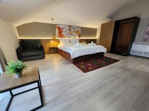 a hotel room with a large bed and a chair at MIK Hotel Korça in Korçë