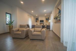 a living room with two chairs and a couch at Vila Rosario in Ponta Delgada