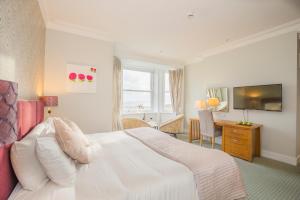 a hotel room with a white bed and a desk at Mulranny Park Hotel in Mulranny