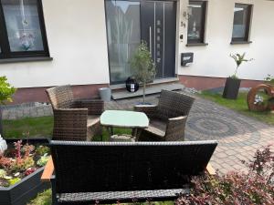 a patio with wicker chairs and a table on a patio at Fewowe Ferienwohnung Wenden in Wenden +5 photos