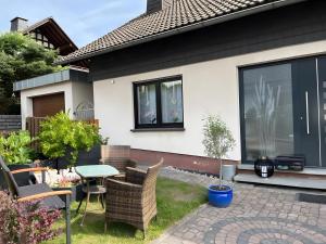 a patio with chairs and a table in front of a house at Fewowe Ferienwohnung Wenden in Wenden