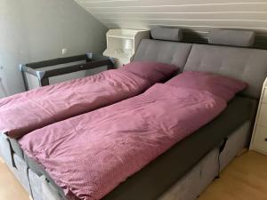 a bed with pink sheets on it in a room at Fewowe Ferienwohnung Wenden in Wenden