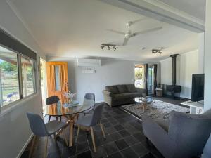 a living room with a couch and a table and chairs at M&M's Lil Gem Berridale in Berridale