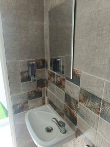 ein Badezimmer mit Waschbecken und Spiegel in der Unterkunft A Personal Room in Bhuj