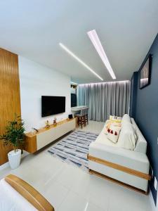 un salon avec un lit et une télévision à écran plat dans l'établissement Charme e conforto na Barra - Perto da Praia- Casa Aurora, à Rio de Janeiro