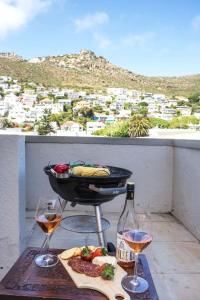 een grill en twee glazen wijn op een balkon bij Comfort & Style apartment 200m to beach with parking in Kaapstad