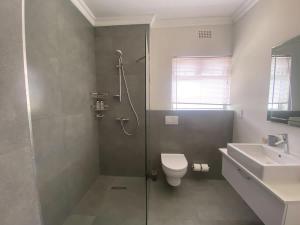 een badkamer met douche, toilet en wastafel bij Comfort & Style apartment 200m to beach with parking in Kaapstad +23 foto's
