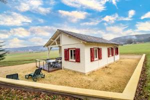 ein kleines Haus mit einem Tisch und einer Bank in der Unterkunft Gite Prairie in Aubas
