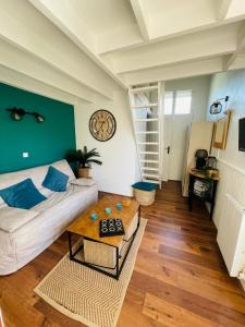 a living room with a couch and a table at Au Chant des Mouettes in Cabourg