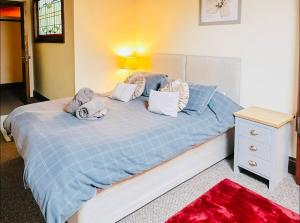 a bedroom with a bed with blue sheets and pillows at Stacey's 4 Bedroom House in Pontypool in Pontypool +2 photos