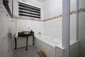 Un baño blanco con bañera y lavabo. en Safi Luxury Apartment 6 - 2 bedroom, en East London