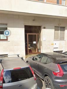 two cars parked in a parking lot in front of a building at Porta Vittoria Residence in Milan