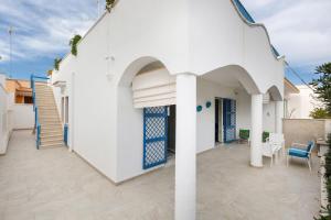 a white house with an archway and a patio at La Controra by BarbarHouse in Specchiolla 