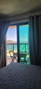 a bedroom with a bed and a view of the ocean at Residence Club Praia Dos Anjos vista al mar in Arraial do Cabo