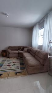 a living room with a brown couch and a window at Casa ampla Praia da Costa - Centro 500 mts da Praia in Vila Velha