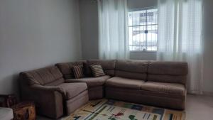a brown couch in a living room with a window at Casa ampla Praia da Costa - Centro 500 mts da Praia in Vila Velha