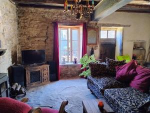 a living room with a couch and a tv at BNB Calme in Saint-Marien