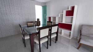 a dining room with a glass table and chairs at Casa ampla Praia da Costa - Centro 500 mts da Praia in Vila Velha