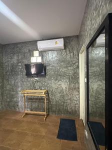 a room with a tv and a table on a wall at Rublom Resort Mae Taeng in Mae Taeng