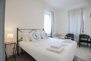 Un dormitorio con una cama blanca con toallas. en SG Rooms - Casa Laura, en Peschiera del Garda