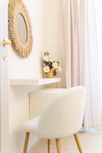 a white chair and a mirror on a wall at Lecco Antico Pozzo - Modern Suite in Lecco +19 photos
