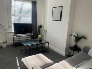 a living room with a couch and a tv at 2Bed Sleeps 3 - Central Near Train Station Wifi in Dartford